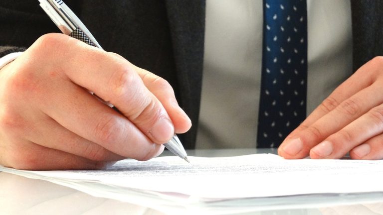 man signing document